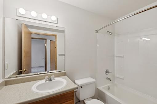 A bathroom with a sink, toilet, and bathtub  at The Timbers by Vintage, Arlington