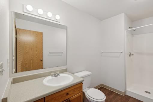 A bathroom with a sink, toilet, and shower.