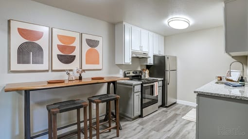 Apartments Hayward for Rent - Austin Commons - Kitchen with Granite-Style Countertops, White Cabinets, and Appliances.