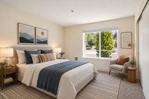 A bedroom with a large bed and a window overlooking a tree.
