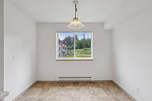 A room with a large window showing a view of houses and trees.