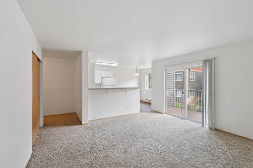 A large, empty room with a carpeted floor and white walls.