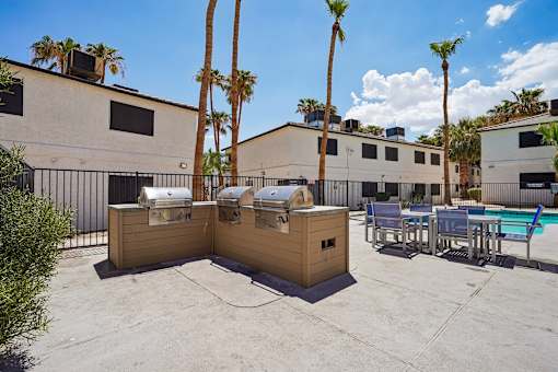 Outdoor grilling stations with dining area by pool at Dash Apartments, Nevada