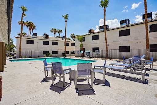 Outdoor pool area with lounge seating and palm trees at Dash Apartments, Nevada, 89104