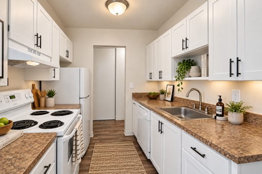 A kitchen with white cabinets and a granite countertop.