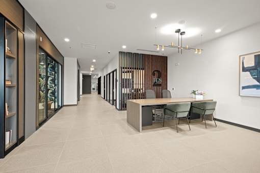 A modern office space with a long hallway, a reception desk, and a framed picture on the wall at Two 10 by Vintage, Shoreline