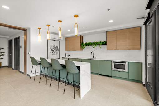 A modern kitchen with green cabinets and a white island at Two 10 by Vintage, Shoreline, WA