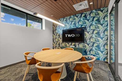 A conference room with a round table and chairs  at Two 10 by Vintage, Shoreline, WA 98133