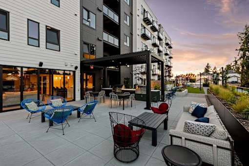 A patio with a table and chairs is surrounded by apartment buildings  at Two 10 by Vintage, 98133