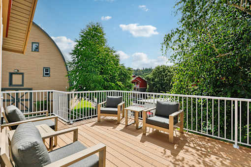 A wooden deck with two chairs and a table  at The Timbers by Vintage, Arlington, WA 98223