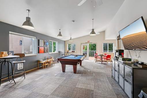 A room with a pool table and a television on the wall  at The Timbers by Vintage, Arlington