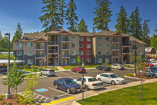 Building exterior and green grounds at SOUTH HILL BY VINTAGE, Puyallup, Washington
