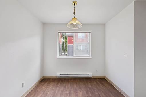 A room with a window and a hanging light fixture.