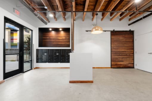 an empty room with a white reception desk and a sliding barn door