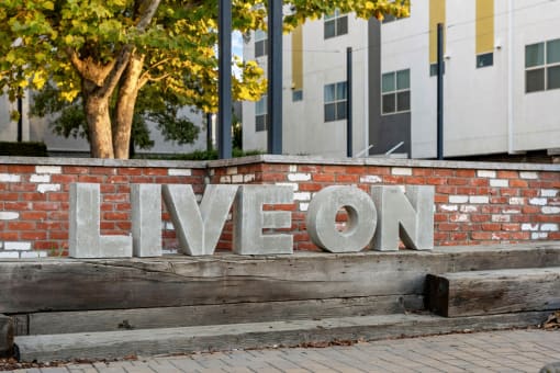 a brick wall with the word live on it in front of a building