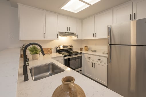 Citrus Heights Apartments - The Arlo - Kitchen with White Cabinets, Quartz Countertops, and Stainless Steel Appliances