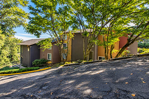 A parking lot in front of a building with trees.