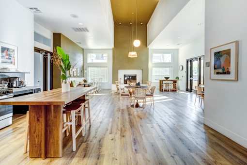 A modern kitchen with a wooden island and chairs at AGAVE APARTMENTS, CA 95757