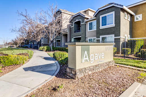 A gated community with a sign that says Agave at AGAVE APARTMENTS, Elk Grove, CA 95757