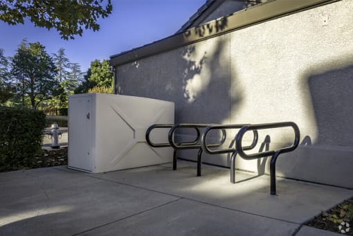 a bench sitting next to a refrigerator on a sidewalk