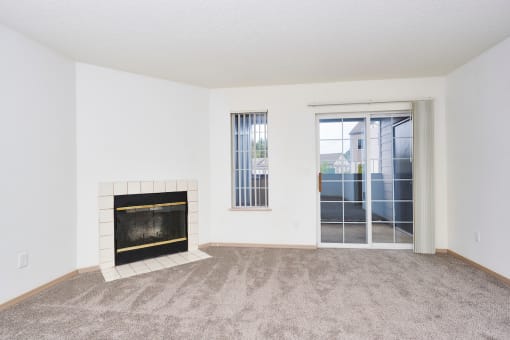 Living area with fireplace and balcony at Devonwood and First Place Apartments, Washington