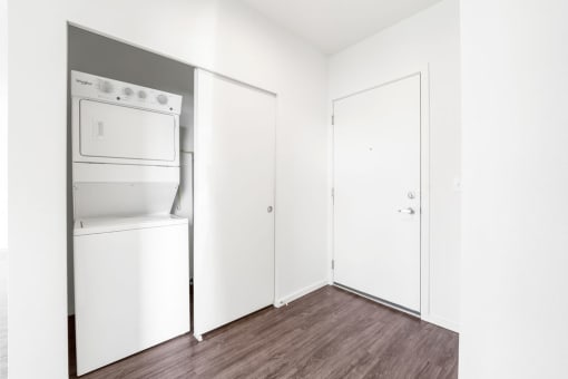 a white room with a white refrigerator and a white washer and dryer