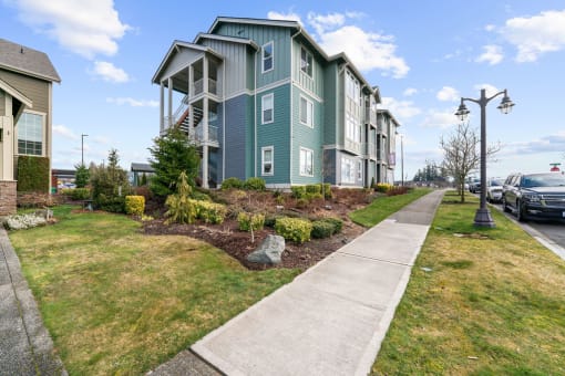 Apartments in Olympia - Briggs Village - Building Exterior with Street Lamps, Sidewalk, and Meticulous Landscaping