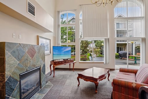 A living room with a fireplace and a flat screen TV at Vintage at Burien,Burien,98168.