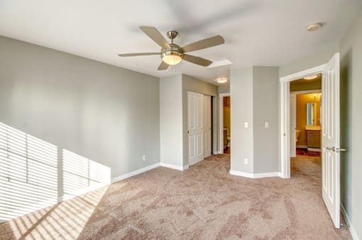 1 BR Apartments in Dupont WA - Clock Tower Village - Spacious Unfurnished Bedroom With a Ceiling Fan, Carpet Flooring, and Natural Light From the Window