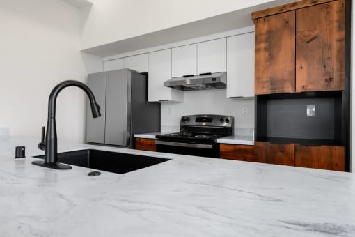 a kitchen with marble counter tops and black appliances