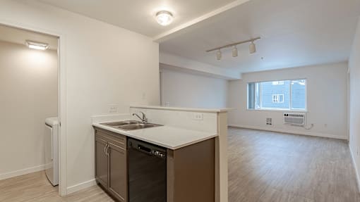 A kitchen with a white counter top and a window at Falls Creek Apartments in Couer d'Alene, ID, 83815