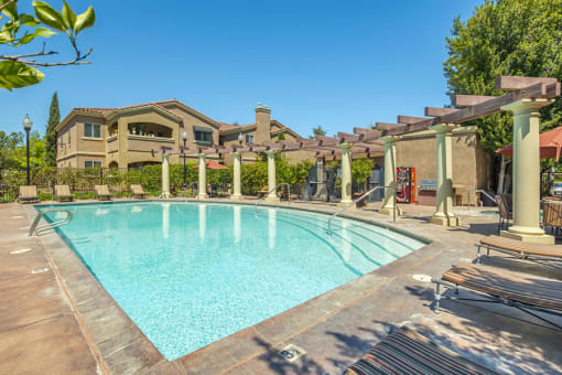 Elk Grove, CA Apartments for Rent- Castellino at Laguna West- Sparkling Pool with Sun Lounge Chairs and Exterior Building View