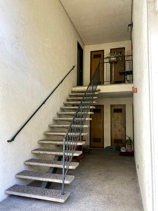 A room with a white floor and a white ceiling with a black pole in the middle.at Via Casitas, Greenbrae, CA 94904