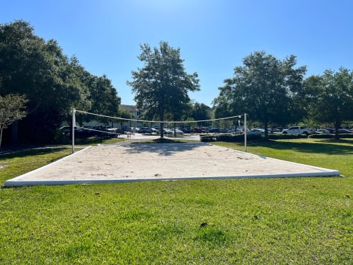 a volleyball court sits in the middle of a grassy field at SUMMERBREEZE & SUMMERSET, ST. AUGUSTINE