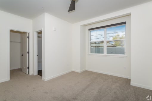 a bedroom with white walls and carpet at THE ANGELINO, Sacramento