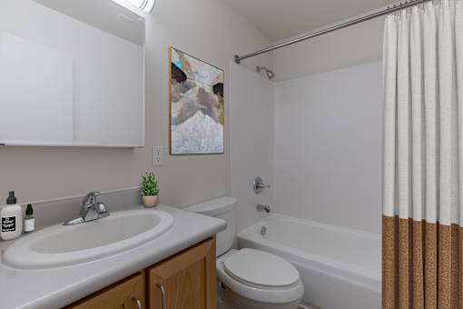 A bathroom with a white sink, toilet, and bathtub at Lake Washington Apartments, Seattle, WA 98118