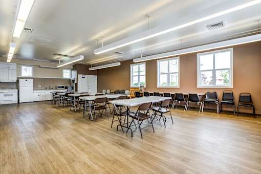 A large room with tables and chairs and a kitchen area.at Lake Washington Apartments, Seattle
