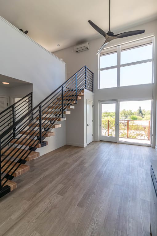a living room with a staircase and a door to a balcony at Luella, Sacramento