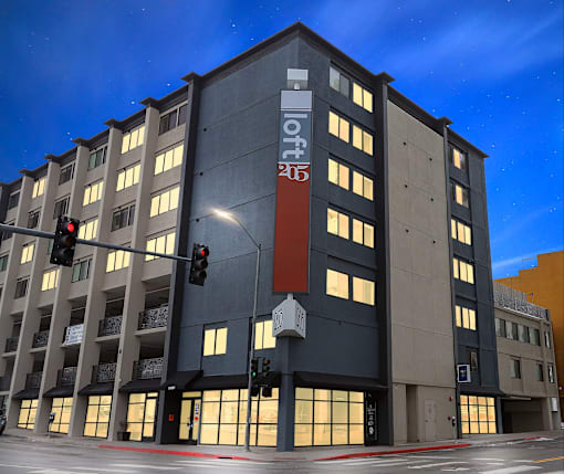 A modern building with a dark grey facade and a red sign on the front at LOFT 205 Apartments, Reno, NV