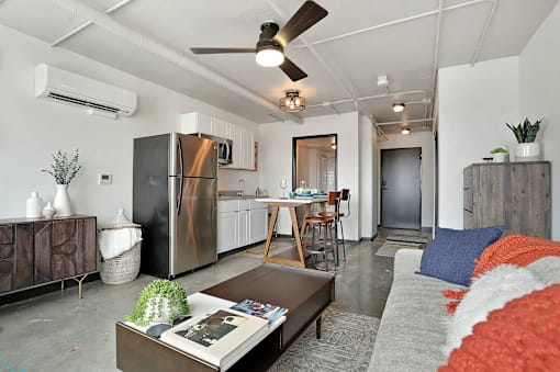 A modern kitchen with a refrigerator, a dining table with chairs, and a living area with a couch and a coffee table at LOFT 205 Apartments, Nevada, 89501