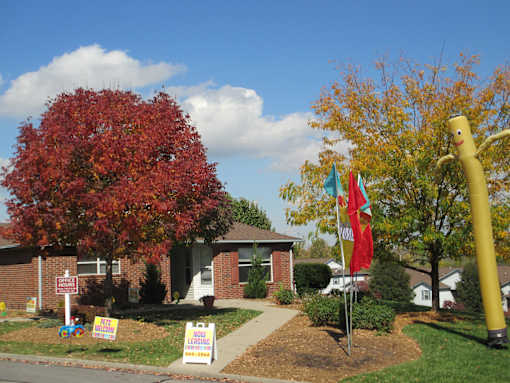 A house with a yard and a sign in front of it.
