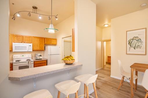 A kitchen with a counter and chairs. at Fairview Village Apartments, Fairview, OR, 97024