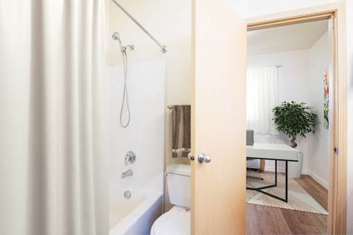 A bathroom with a white tub and a wooden door. at Fairview Village Homes, Oregon