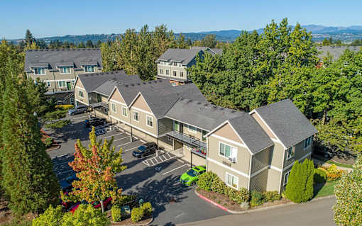 A large building surrounded by trees and a parking lot. at Fairview Village Homes, Fairview, OR