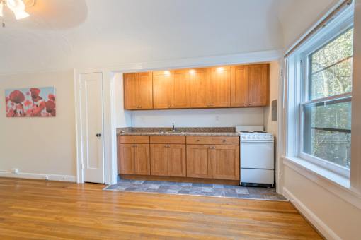 A kitchen with wooden cabinets and a white dishwasher.at Palladian Apartments, Oregon, 97201?