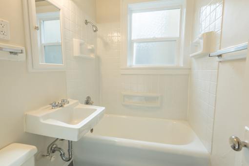 A white bathroom with a tub, sink, and toilet.at Palladian Apartments, Oregon ? 