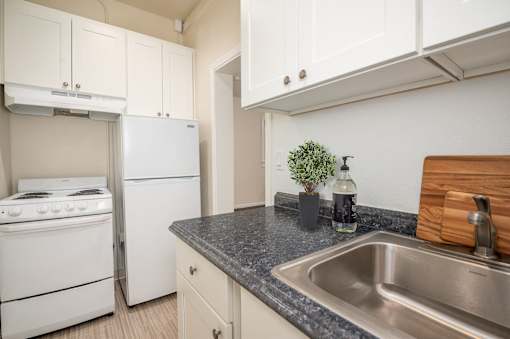A kitchen with a stove, dishwasher, and sink.at Palladian Apartments, Portland, OR ? 