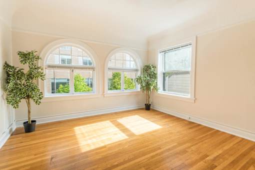 A room with wooden floors and two potted plants.at Palladian Apartments, Portland, OR 97201 ? 