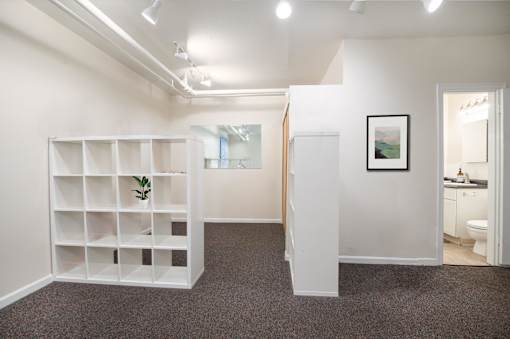 A room with a white shelf, a plant, and a picture on the wall.at Palladian Apartments, Portland, OR ? 