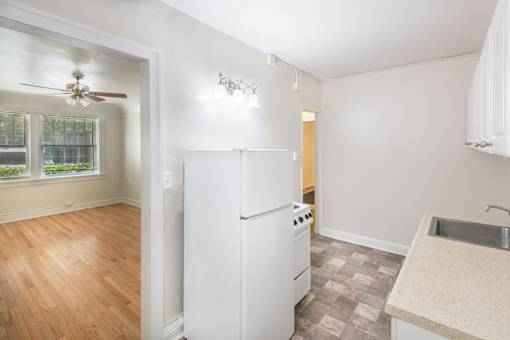 A kitchen with a white refrigerator and a fan on the ceiling.at Palladian Apartments, Portland Oregon ? 
